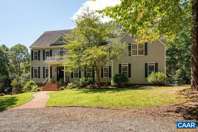 a front view of a house with a yard and trees