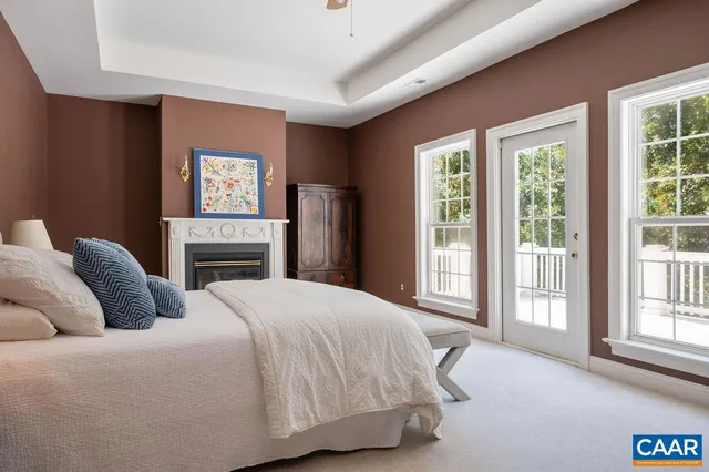 a bedroom with a bed painting on wall and windows