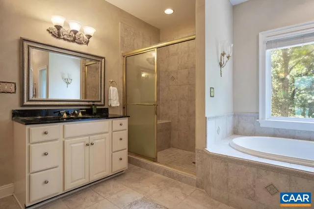 a bathroom with a tub a sink and a mirror