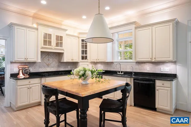 a kitchen with stainless steel appliances granite countertop white cabinets a stove a sink and a refrigerator