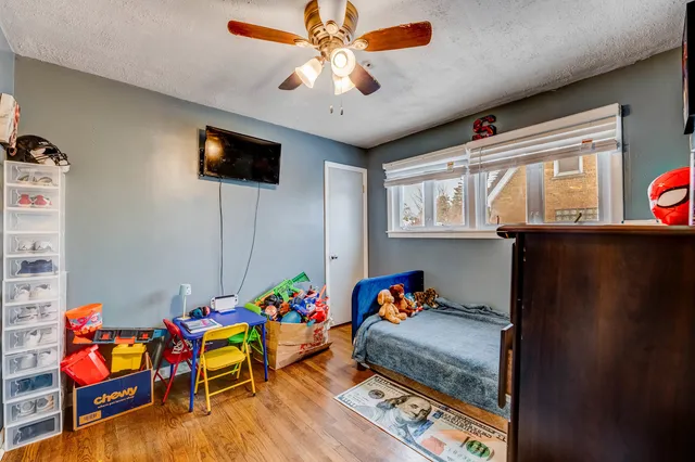 a bedroom with furniture and a chandelier fan