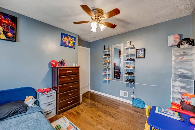a bedroom with a bed and wooden floor