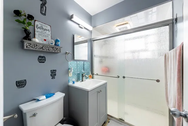 a bathroom with a sink mirror toilet and next to a window