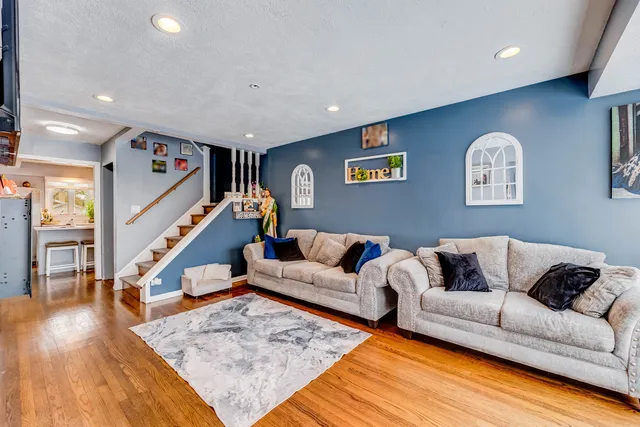 a living room with furniture and wooden floor