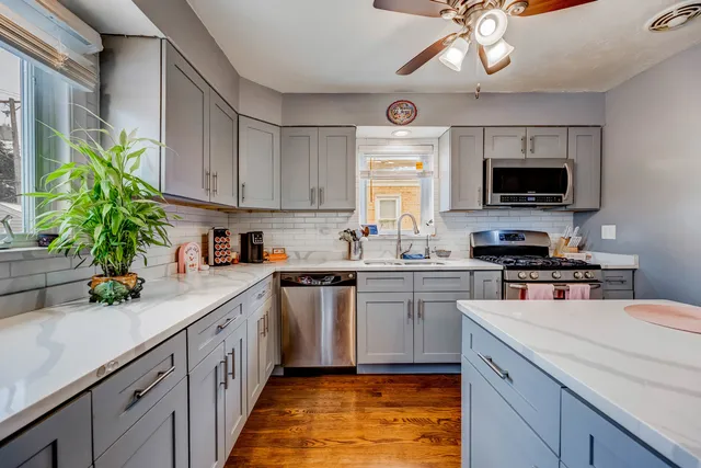 a kitchen with a sink a microwave a stove and cabinets