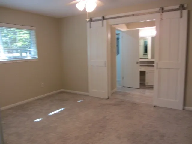 an empty room with windows and cabinet