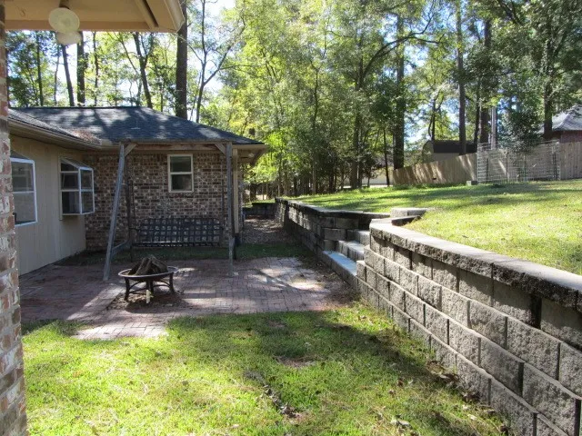 a view of a backyard with table and chairs and a barbeque