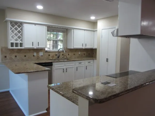 a kitchen with stainless steel appliances granite countertop a sink and a refrigerator