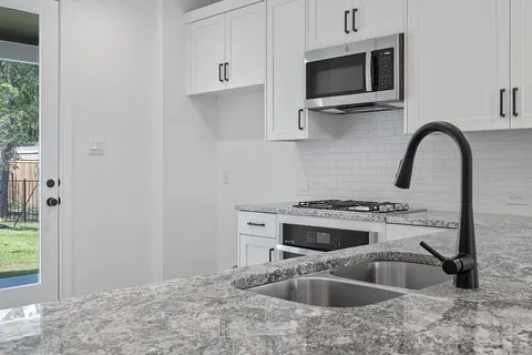 a kitchen with sink a microwave and stove
