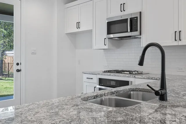 a kitchen with sink a microwave and stove