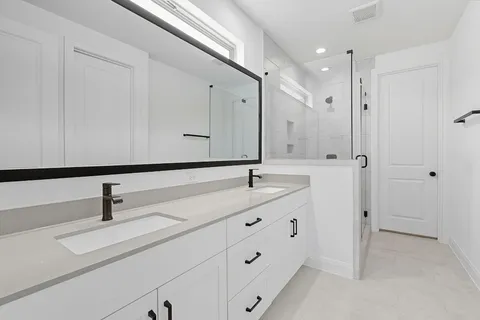 a bathroom with a double vanity sink and mirror