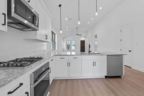a kitchen with stainless steel appliances granite countertop a stove and a sink