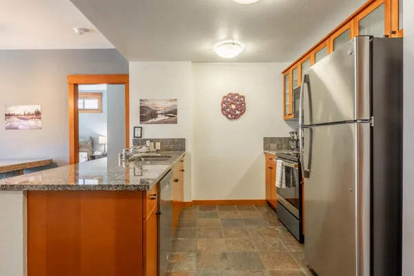 a kitchen with stainless steel appliances granite countertop a refrigerator and a stove