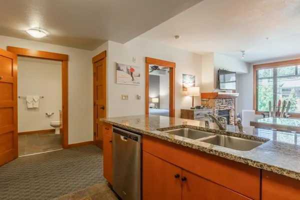 a kitchen with granite countertop a sink and a refrigerator