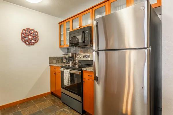 a kitchen with stainless steel appliances a refrigerator stove and microwave