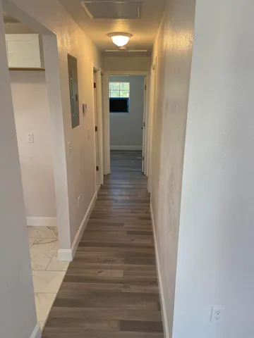 a view of a hallway with wooden floor