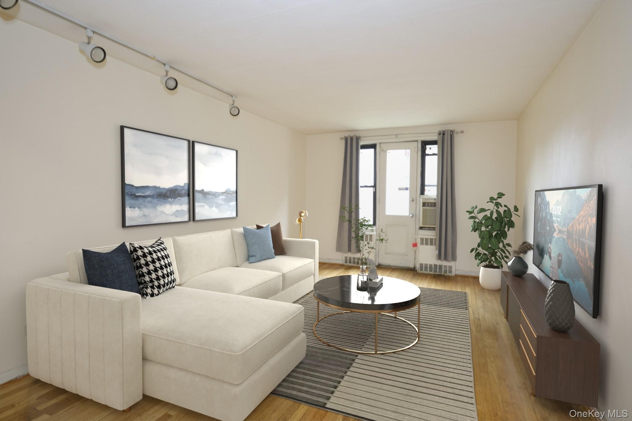 150-11 72nd Road, Unit 1C Queens, NY 11367 - Photo 1 of 25 Living area with rail lighting, light wood-type flooring, and radiator heating unit