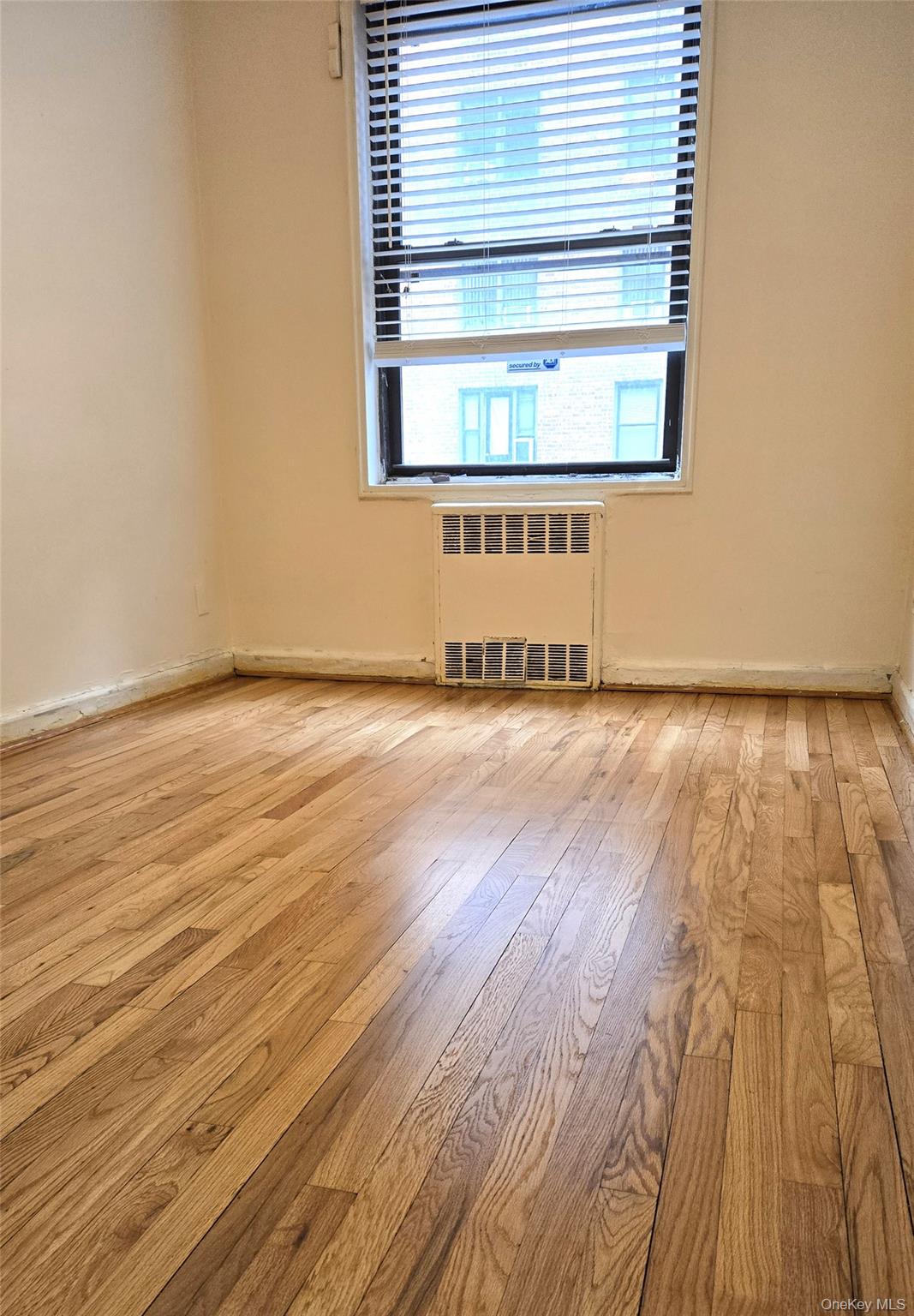 150-11 72nd Road, Unit 1C Queens, NY 11367 - Photo 12 of 25 Unfurnished room featuring radiator heating unit and light wood-type flooring
