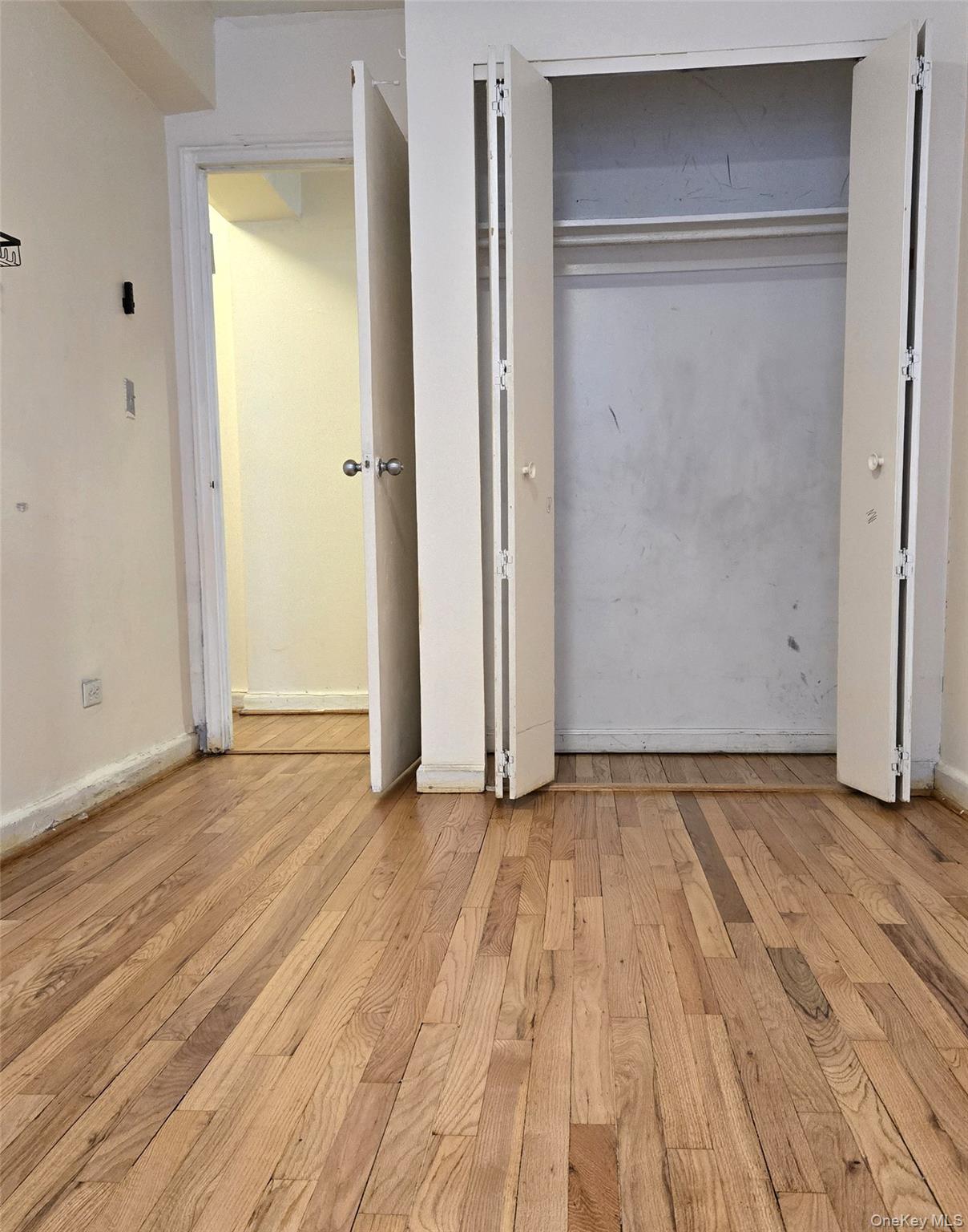 150-11 72nd Road, Unit 1C Queens, NY 11367 - Photo 13 of 25 Unfurnished bedroom featuring light wood finished floors and baseboards