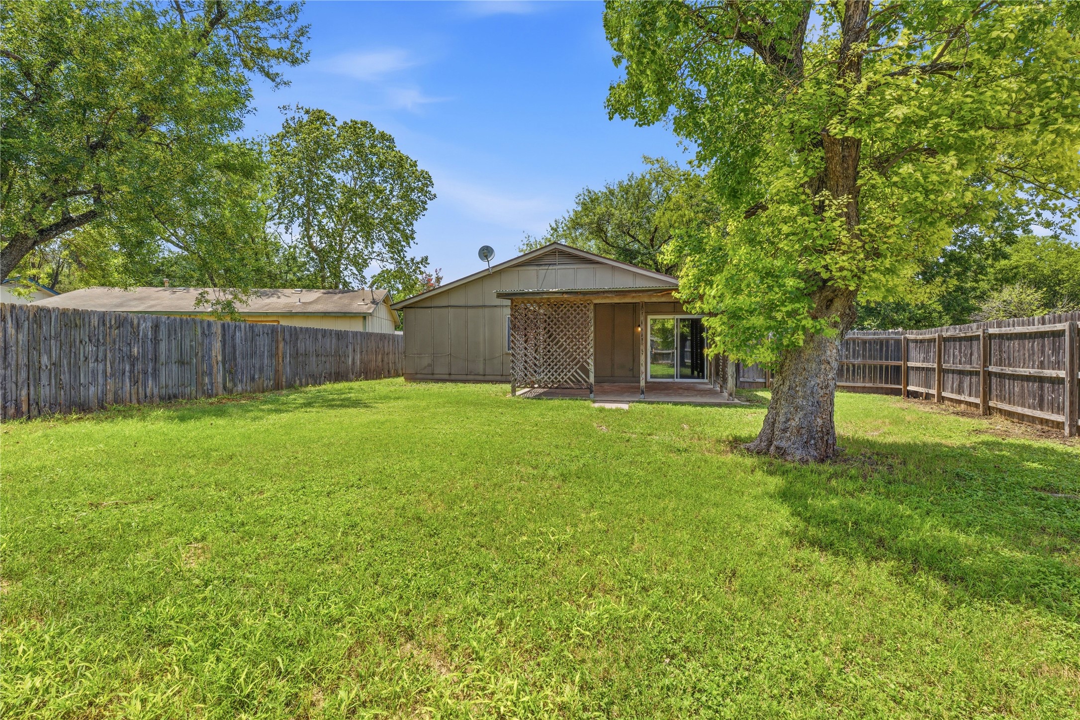 6205 Shadow Bend Austin, TX 78745 - Photo 7 of 31 A spacious backyard with mature trees provides ample green space for outdoor enjoyment.