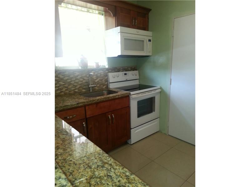 321 Northwest 13th Avenue Miami, FL 33125 - Photo 8 of 13 a kitchen with stainless steel appliances granite countertop a sink and a stove