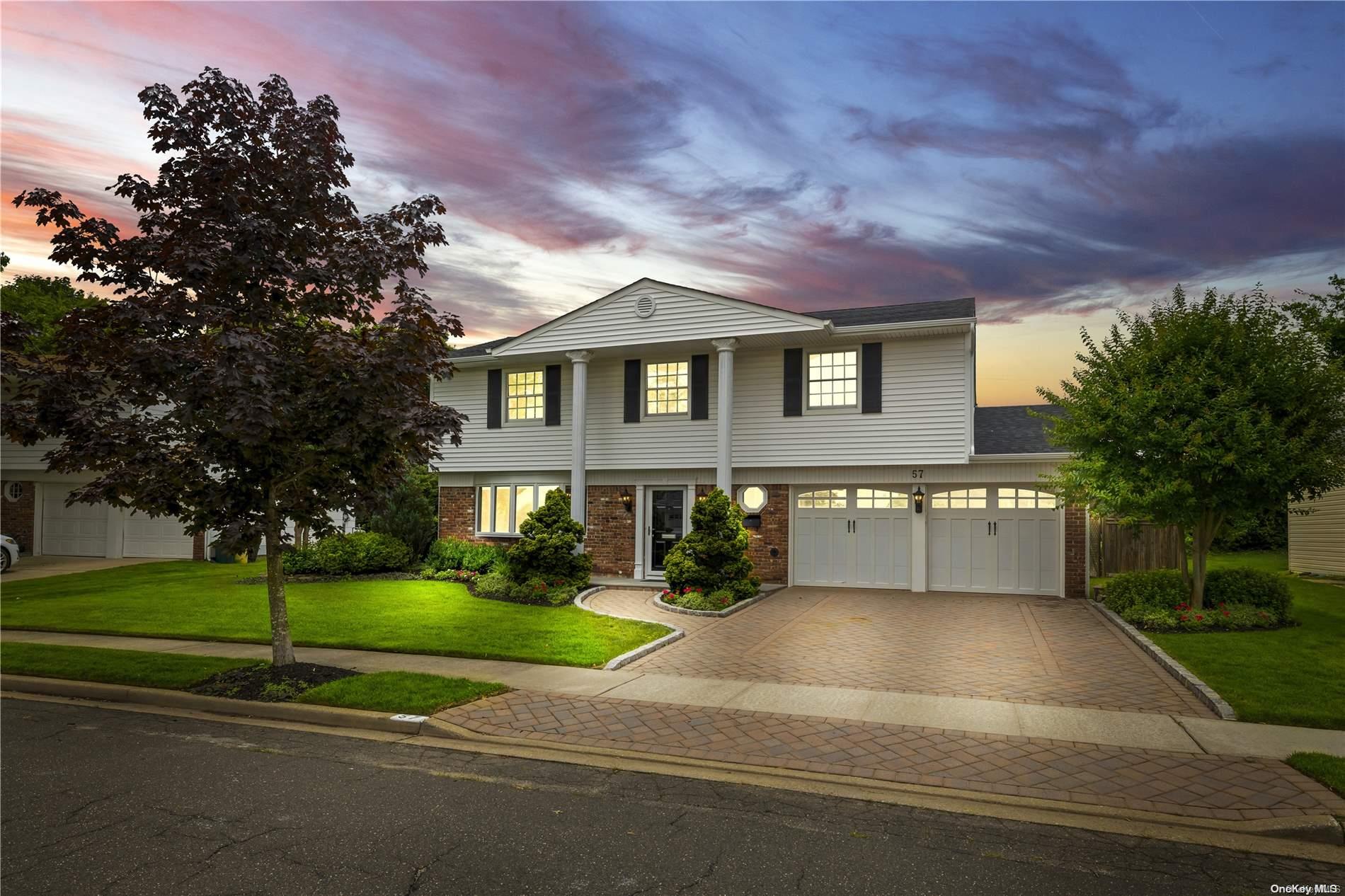 a front view of a house with a yard and trees