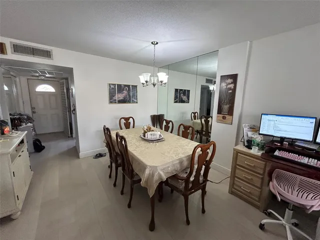 a view of a dining room with furniture and chandelier