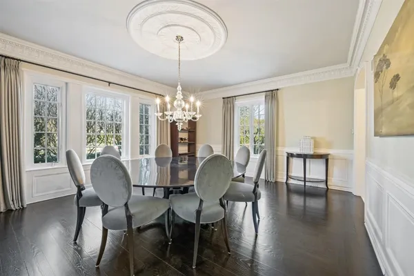 a dining room with furniture a chandelier and wooden floor