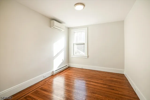 a view of a room with wooden floor and a window