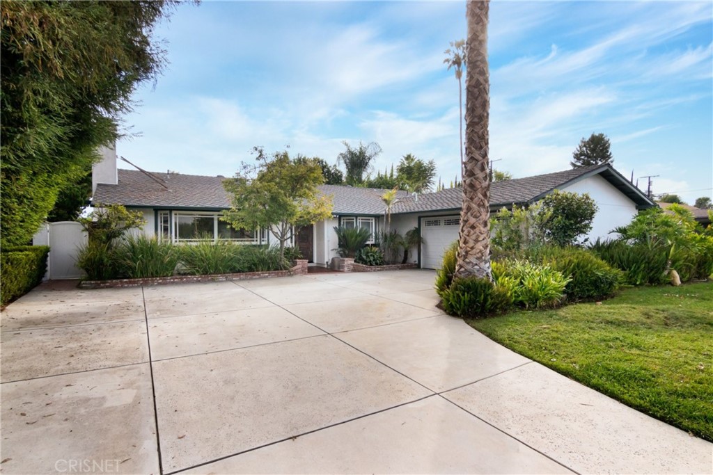 22252 Bassett Street Canoga Park, CA 91303 - Photo 1 of 30 a front view of a house with a garden