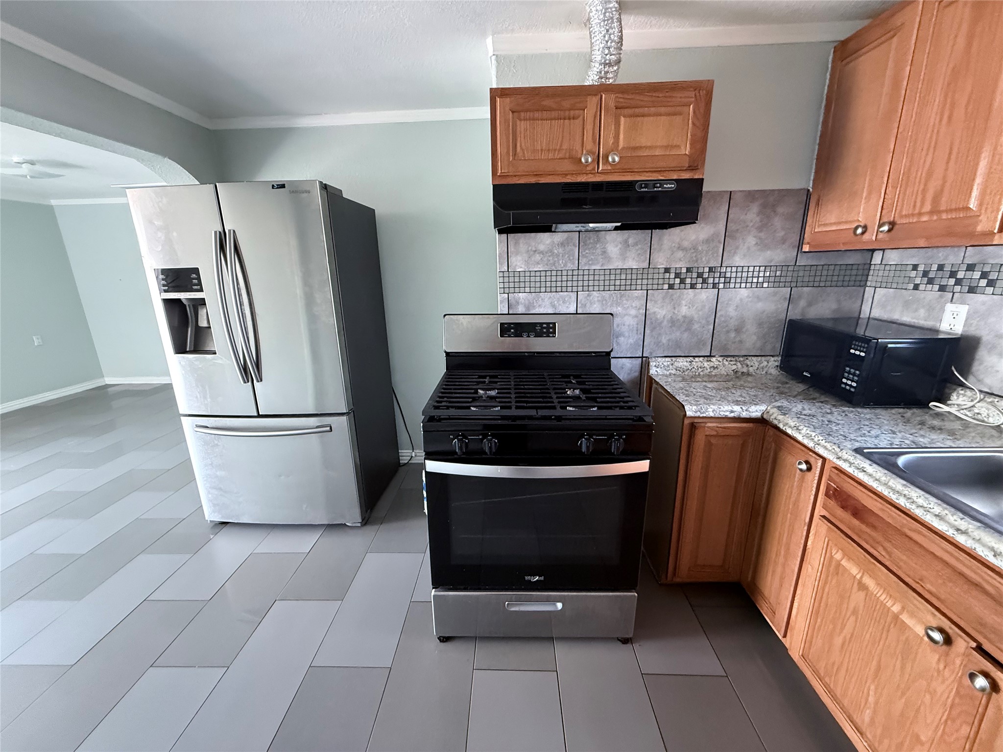13809 Hershe Street, Unit B Houston, TX 77015 - Photo 1 of 9 a kitchen with granite countertop a stove a refrigerator and a sink