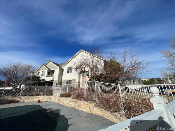 a front view of a house with a yard and potted plants