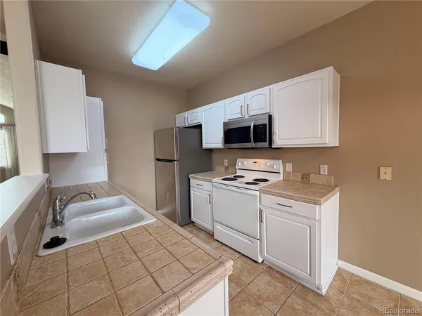 a kitchen with stainless steel appliances a sink stove and microwave