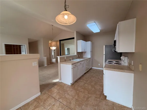 a large kitchen with a stove a sink dishwasher and a refrigerator