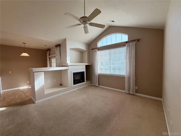 an empty room with windows and fireplace
