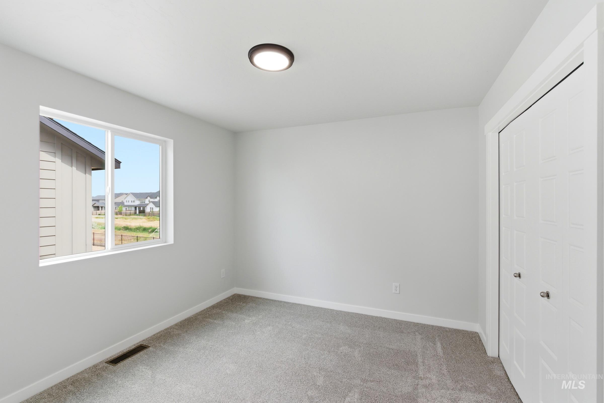 12829 Decatur Street Nampa, ID 83651 - Photo 26 of 33 Light gray carpeting and a neutral wall color define this room, featuring a white-framed window