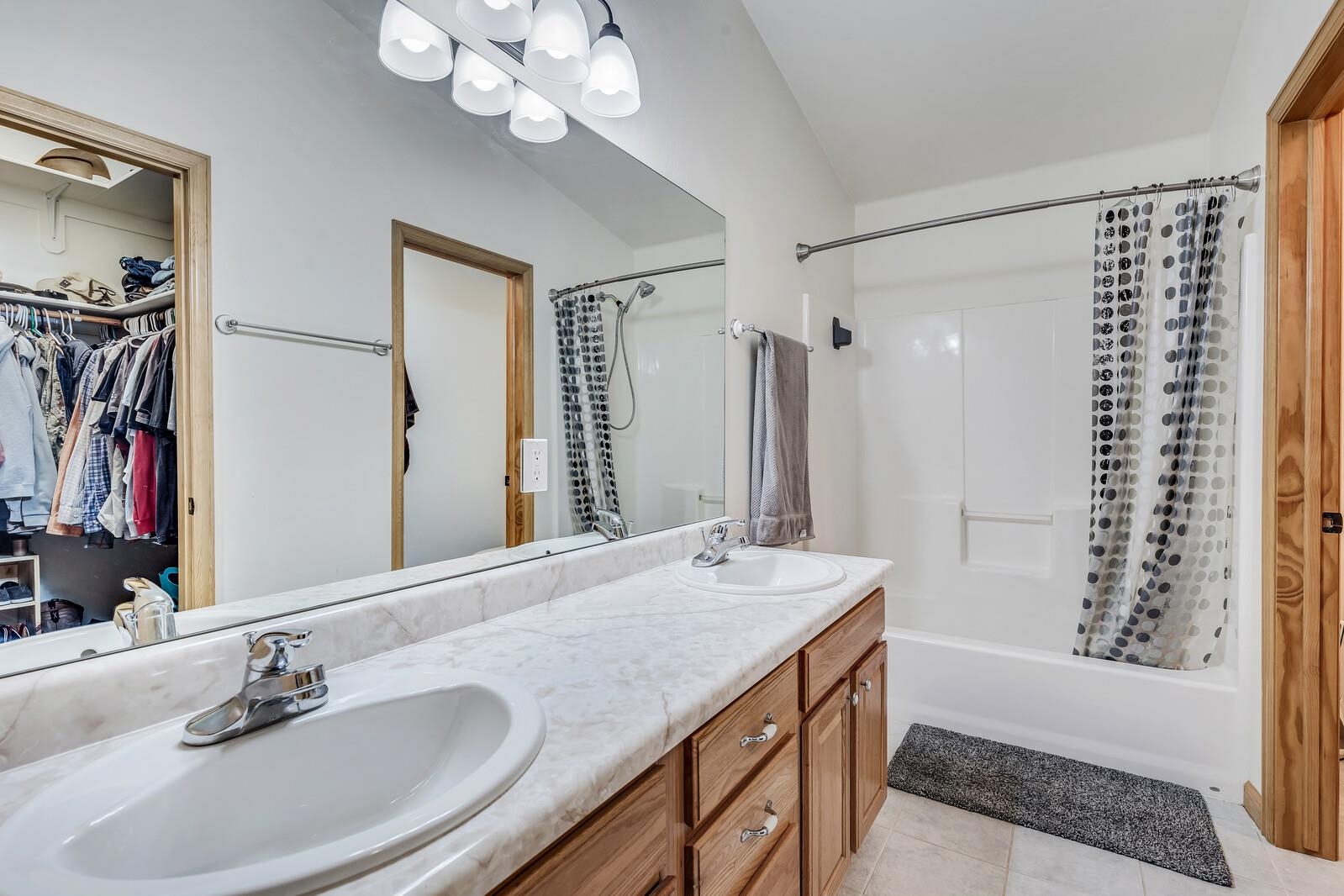 1197 East 18th Way Rifle, CO 81650 - Photo 13 of 19 a bathroom with a granite countertop sink a mirror and a shower
