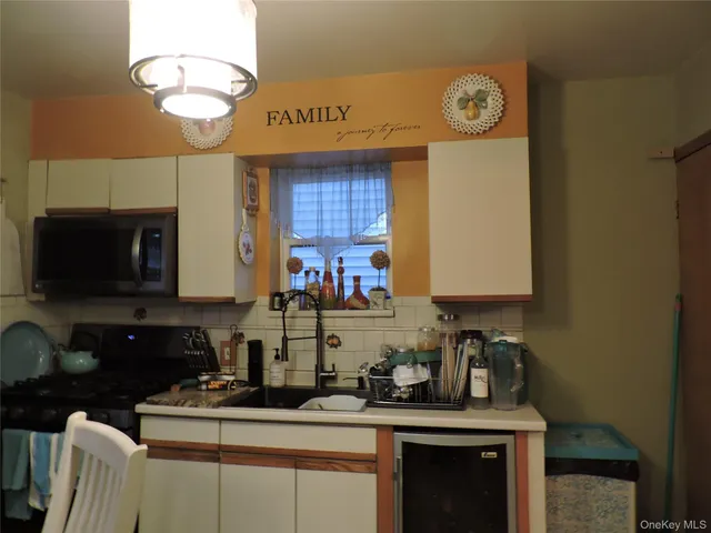 a kitchen with granite countertop a sink a stove and a microwave
