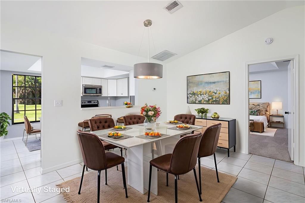 5671 Green Boulevard Naples, FL 34116 - Photo 12 of 37 a dining room with a wooden table and chairs