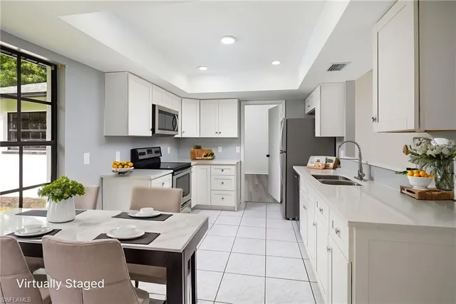 a kitchen with white cabinets and white appliances