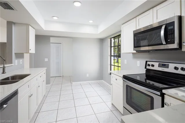 a kitchen with stainless steel appliances a sink a stove a microwave a sink and cabinets