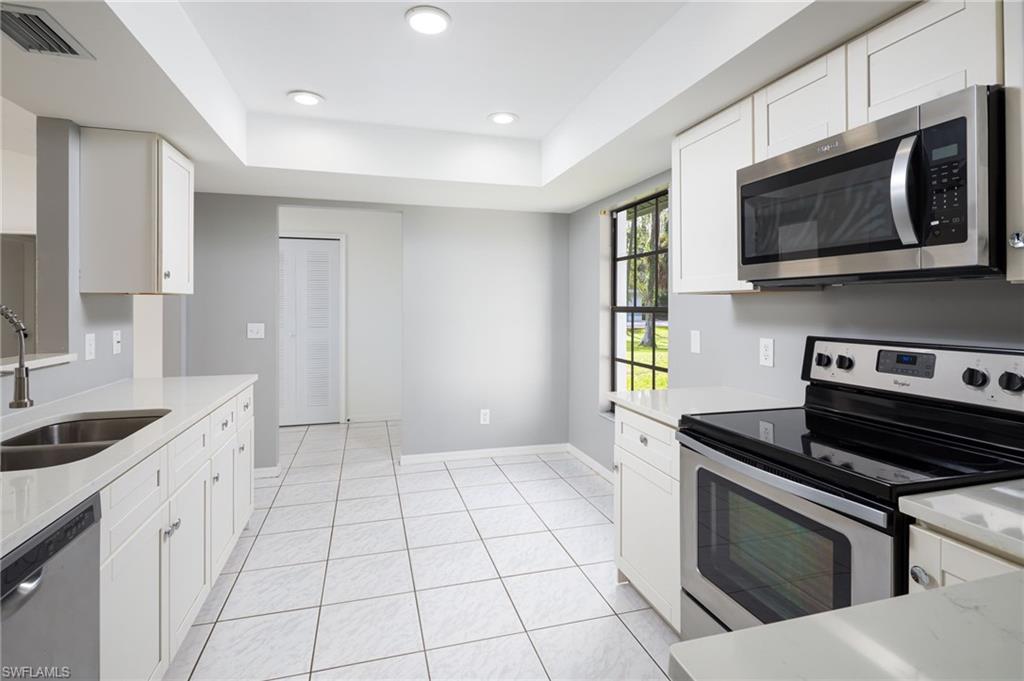5671 Green Boulevard Naples, FL 34116 - Photo 17 of 37 a kitchen with stainless steel appliances a sink a stove a microwave a sink and cabinets