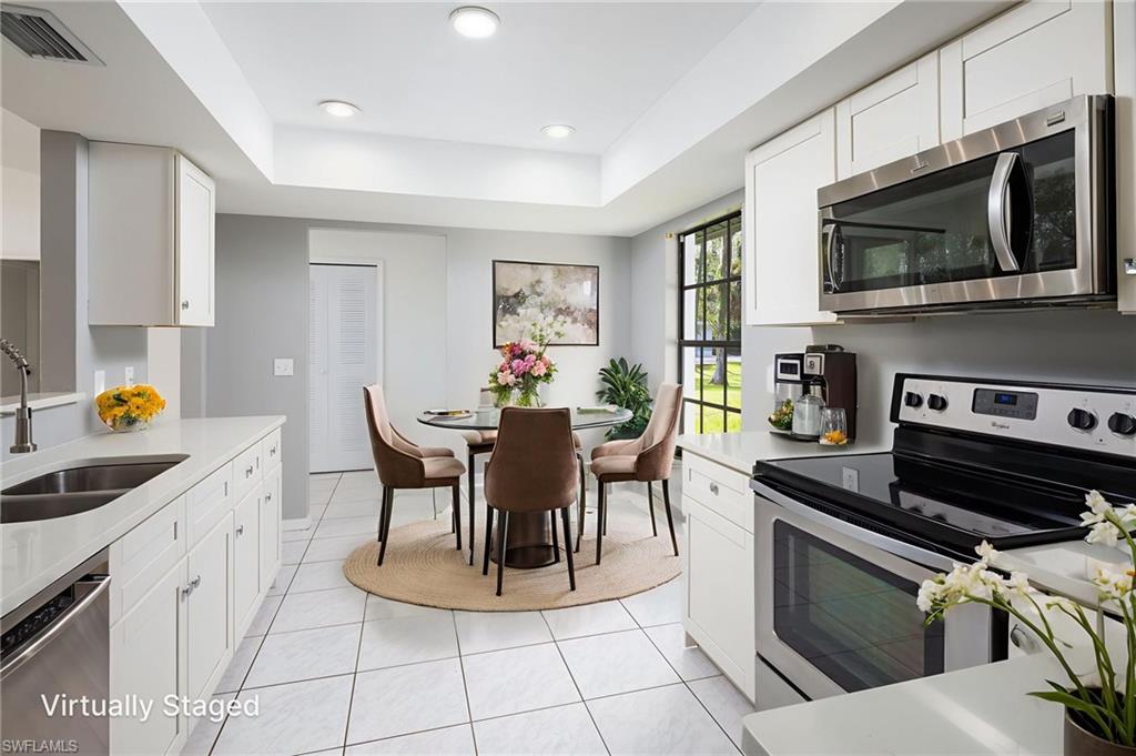 5671 Green Boulevard Naples, FL 34116 - Photo 18 of 37 a kitchen with a stove a sink and a microwave