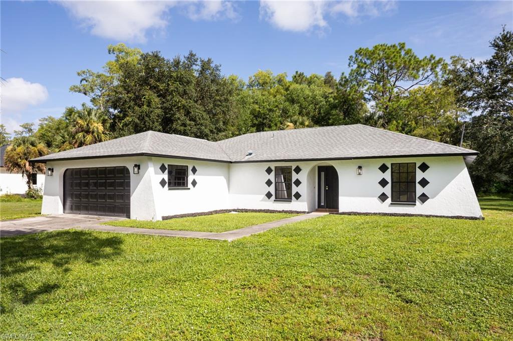 5671 Green Boulevard Naples, FL 34116 - Photo 2 of 37 a front view of a house with a yard
