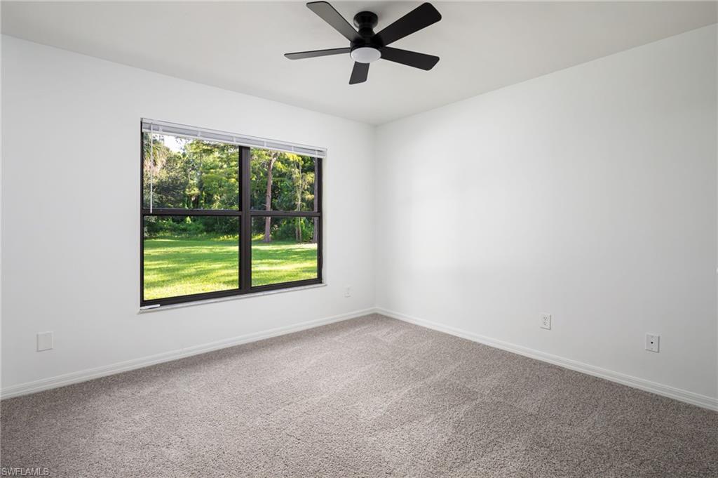 5671 Green Boulevard Naples, FL 34116 - Photo 23 of 37 an empty room with a window and a ceiling fan