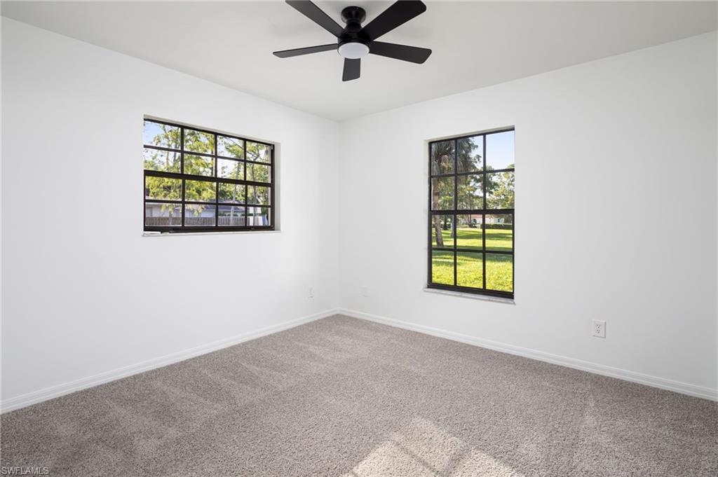 5671 Green Boulevard Naples, FL 34116 - Photo 26 of 37 an empty room with windows and ceiling fan