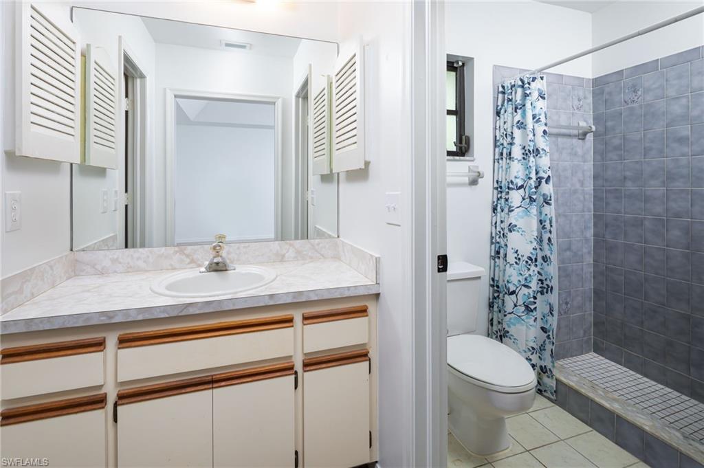 5671 Green Boulevard Naples, FL 34116 - Photo 29 of 37 a bathroom with a granite countertop sink a toilet a shower and a mirror