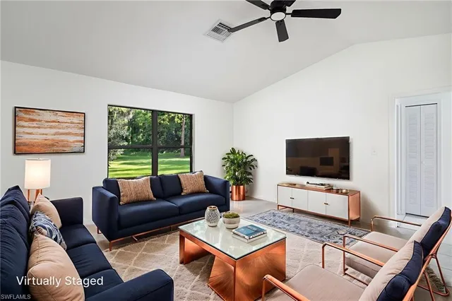 a living room with furniture a flat screen tv and a window