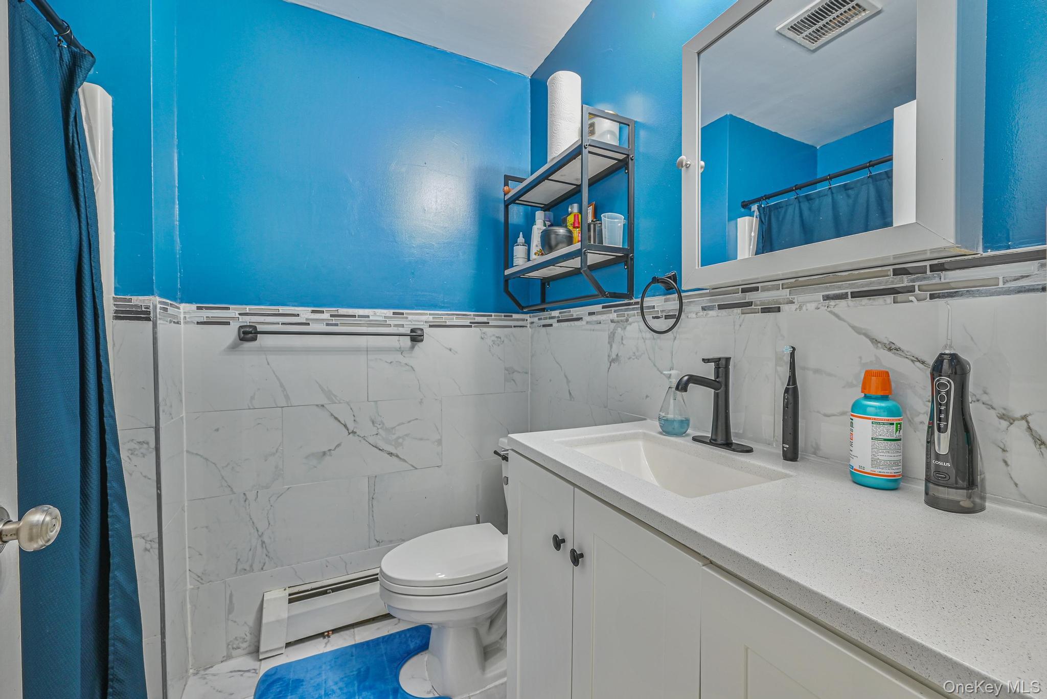 2087 Union Street Brooklyn, NY 11212 - Photo 10 of 20 a bathroom with a sink a toilet and shower curtain