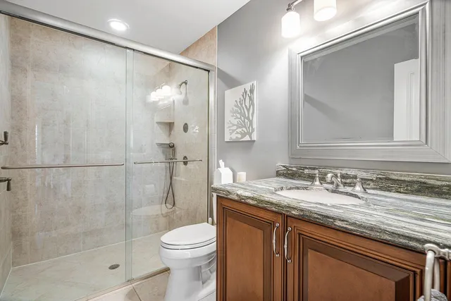 a bathroom with a granite countertop sink toilet and shower